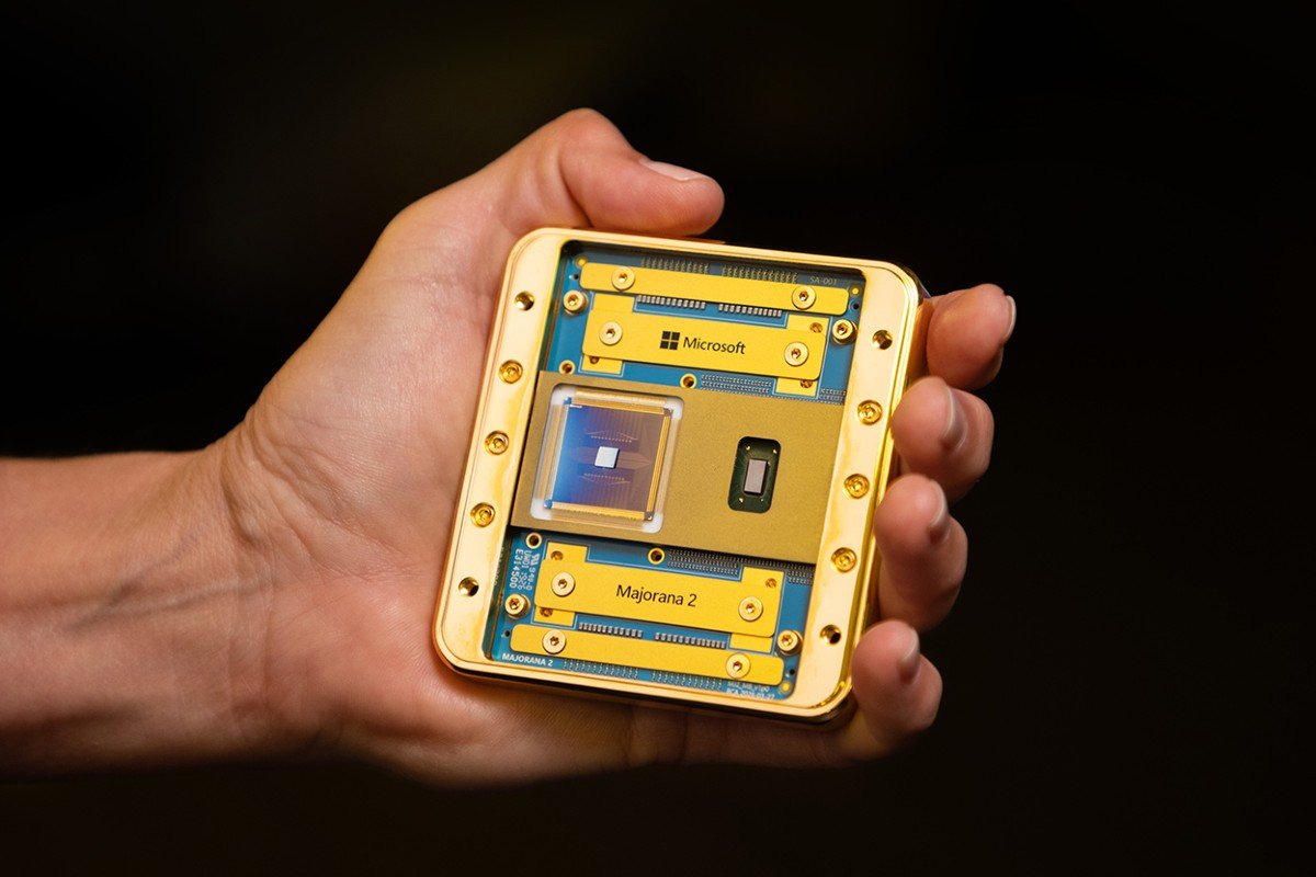 A hand holding a gold-framed chip labeled Majorana 2, with a Microsoft logo on the board.